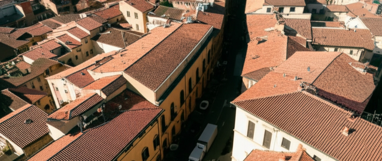 Veduta aerea iperrealistica di un camion per traslochi che attraversa le vie di Grosseto, mostrando l'architettura unica della città.