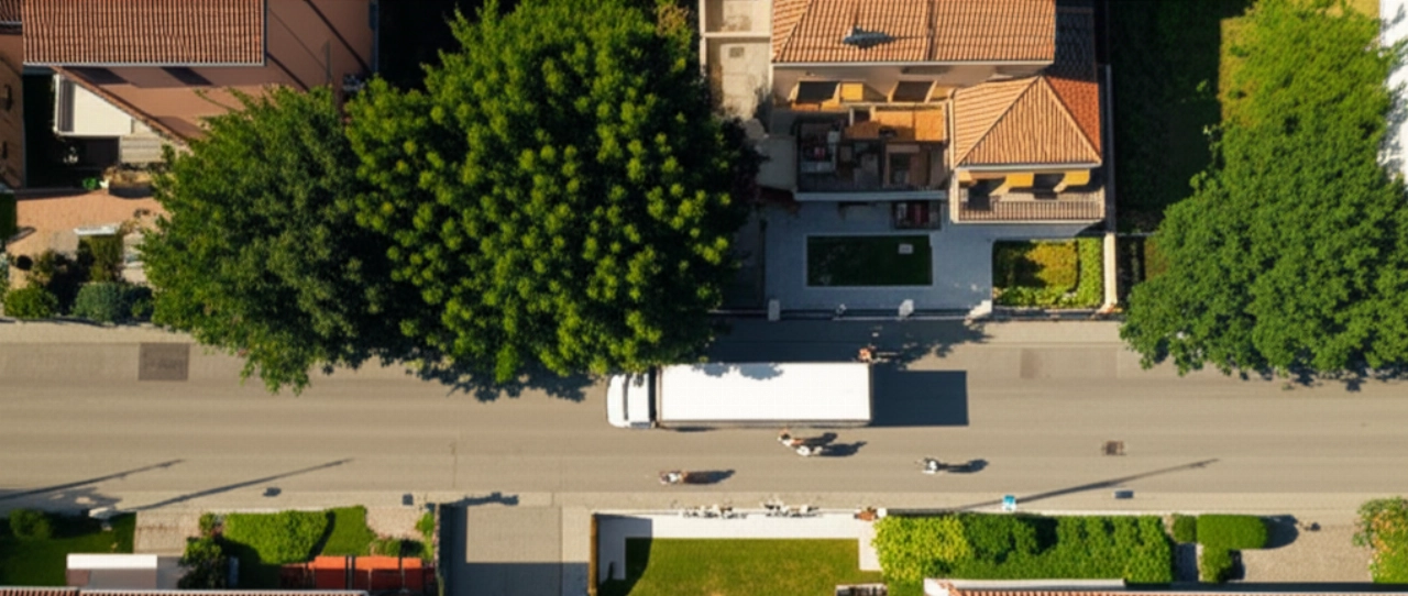 Vista aerea di un camion dei traslochi moderno e traslocatori caucasici che lavorano in una strada residenziale di Padova.